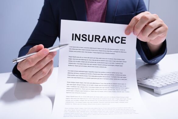 Contact a Colorado Truck Accident Lawyer Today A person holding an insurance document and a pen, ready to explain or sign it.